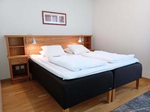 a large bed with white sheets and pillows at Dählie Åre Torg Apartments in Åre