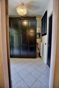 a hallway with black doors and a tile floor at Studio Bellavista in Acquaseria