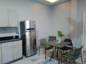 a kitchen with a table with chairs and a refrigerator at Adonai Hotel & Apartment in Spintex