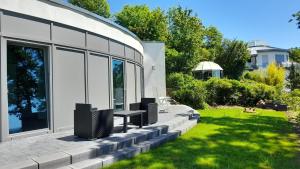 a patio with two benches and a grass yard at Bungalow Vulkanblick in Manderscheid