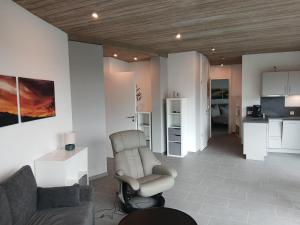 a living room with a couch and a chair at Bungalow Vulkanblick in Manderscheid