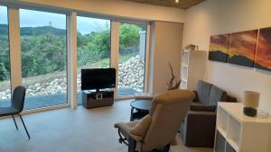 a living room with a couch chair and a television at Bungalow Vulkanblick in Manderscheid