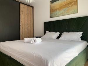 a bedroom with a large white bed with a green headboard at Luxury Central Monarch Residence Apartment Sleeps 5 in Timişoara