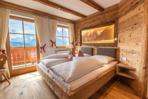 a bedroom with a large bed in a room with windows at Egarterhof in San Candido
