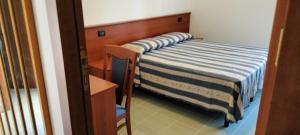 a small bedroom with a bed and a table at Oasi della Divina Volontà in San Giovanni Rotondo
