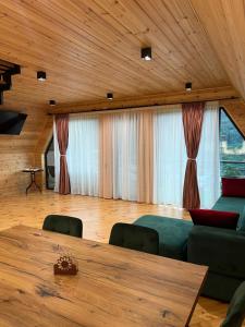 a dining room with a table and a couch at Horizon Mestia - Premium Chalets With Panoramic Views in Mestia