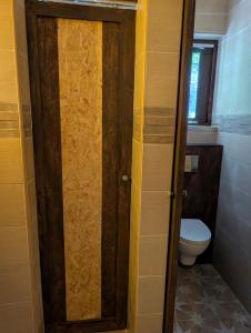 a bathroom with a toilet and a wooden door at ZenGardenCV in Lazareto
