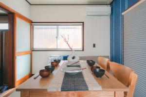 a dining room table with bowls and a vase on it at Odawara Nautical Nook in Odawara