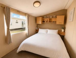 a small bedroom with a bed and a window at Seaside Escape at St Osyth in Clacton-on-Sea +11 photos