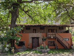 an orange house with a staircase and a tree at ZenGardenCV in Lazareto