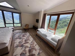 a bedroom with a bed and a large window at Meşeiçi Butik Aile Otel in Macka