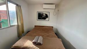 a small bedroom with a bed and a window at Aurora in Carmelo