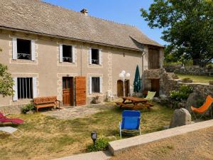 a house with a yard with chairs and a table at Le Refuge de l'Argence in Alpuech
