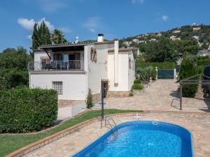 a villa with a swimming pool in front of a house at Villa Las Dos Rocas in Calonge
