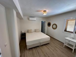 a white bedroom with a bed and a window at Villa Las Dos Rocas in Calonge +33 photos