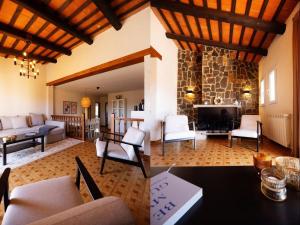 a living room filled with furniture and a stone fireplace at Villa Las Dos Rocas in Calonge