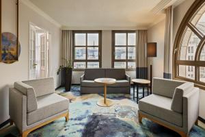 a living room with two chairs and a table at Hamburg Marriott Hotel in Hamburg +64 photos