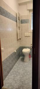 a bathroom with a toilet and a tiled floor at Oasi della Divina Volontà in San Giovanni Rotondo