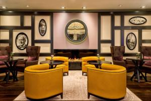 a restaurant with yellow chairs and tables and clocks at Hamburg Marriott Hotel in Hamburg