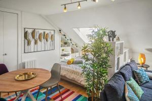 a living room with a bed and a table at Studio "En Coeur de Ville" - Proche Mairie et Quartier Perret - Calme et Charmant in Le Havre