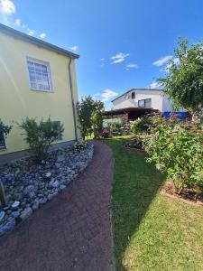 a house with a stone path next to a yard at Seestern in Rerik +4 photos
