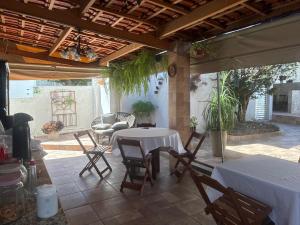 a patio with a table and chairs on a patio at Hospedagem da Néli in Aparecida