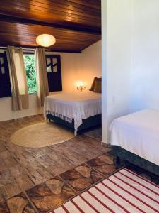 a bedroom with two beds and a large window at Domingas in Ilha de Boipeba