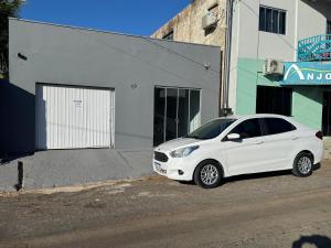 a white car parked in front of a building at Apartamento privado in Primavera do Leste