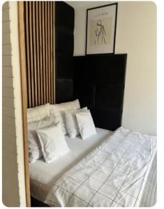 a bedroom with a bed with white sheets and pillows at Apartament Zamojska - GarwoNocka in Garwolin