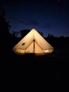 a tent is lit up at night at Lyng Farm Campsite in Brisley