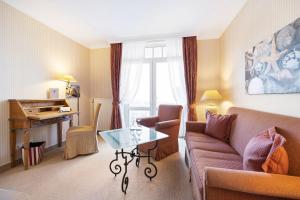 a living room with a couch and a table at Strandhotel Sylt Westerland in Westerland