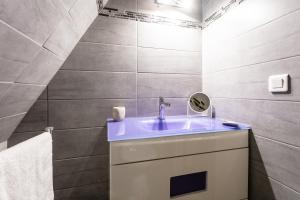 a bathroom with a sink and a mirror at La Tour Aliénor, maison de caractère du XIVème siècle in Beynac-et-Cazenac