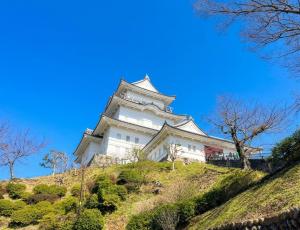a large white building on top of a hill at Odawara Nautical Nook in Odawara
