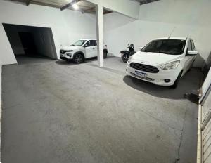 two cars parked in a garage with a motorcycle at Apartamento privado in Primavera do Leste
