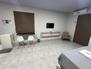 a room with two chairs and a tv on the wall at Apartamento privado in Primavera do Leste