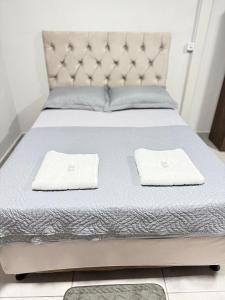 a bed with two white towels on top of it at Apartamento privado in Primavera do Leste