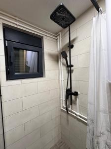 a bathroom with a shower with a television on the wall at Cottage Magdalena in Žabljak +12 photos
