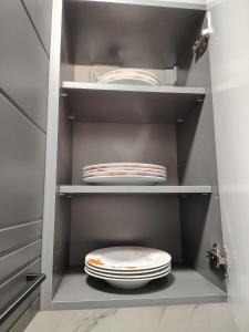 a closet with a stack of plates and a toilet in it at David Apartament in Hunedoara +31 photos