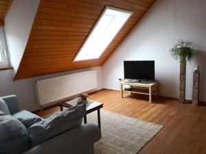 a living room with a couch and a tv at Ferienwohnung Kleine Auszeit in Bastheim