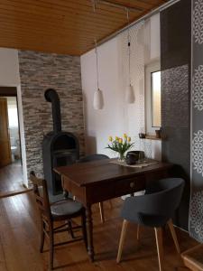 a kitchen with a wooden table and a wood stove at Ferienwohnung Kleine Auszeit in Bastheim