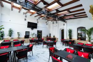 a restaurant with tables and chairs and a flat screen tv at Hotel Dacia in Lugoj
