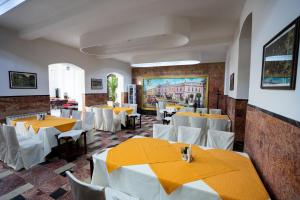 a restaurant with tables and chairs and a painting on the wall at Hotel Dacia in Lugoj