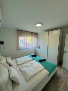 a bedroom with a large white bed with a window at BB Riviera Resort in Balatonboglár