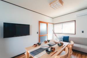 a dining room with a table and a tv at Odawara Nautical Nook in Odawara