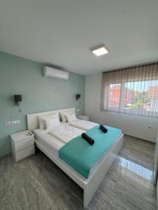 a bedroom with a large bed with a blue blanket at BB Riviera Resort in Balatonboglár