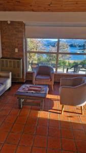 a living room with two chairs and a coffee table at Cabañas Mateo in Villa Pehuenia +5 photos