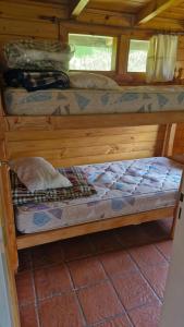 two bunk beds in a wooden cabin at Cabañas Mateo in Villa Pehuenia