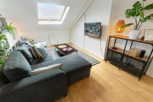 a living room with a couch and a table at Studio "En Coeur de Ville" - Proche Mairie et Quartier Perret - Calme et Charmant in Le Havre