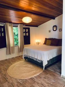 a bedroom with a large bed with a wooden ceiling at Domingas in Ilha de Boipeba