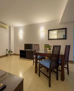 a dining room with a table and chairs and a mirror at Vip Executive Suites Maputo in Maputo